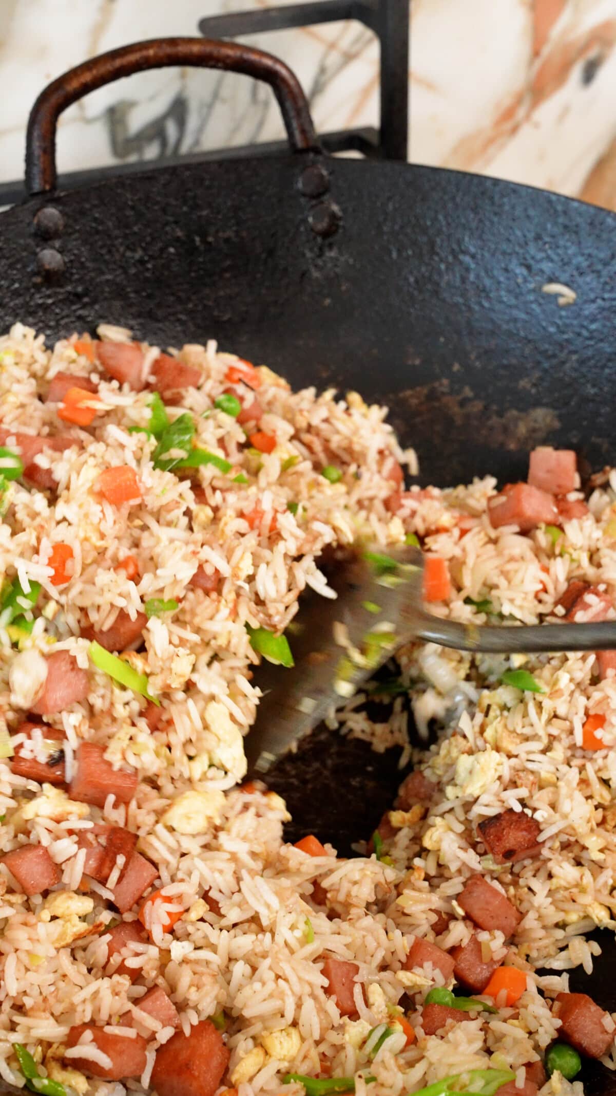 Mixing Spam Fried Rice with a spatula.