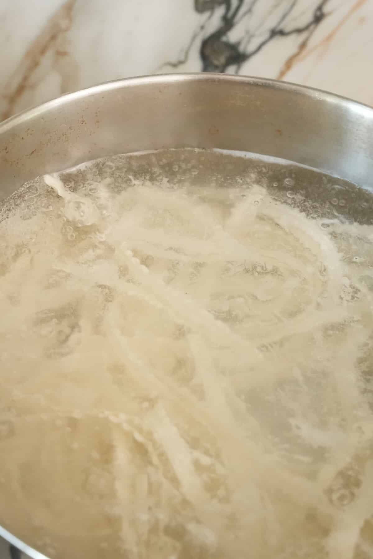 Noodles boiling in water.