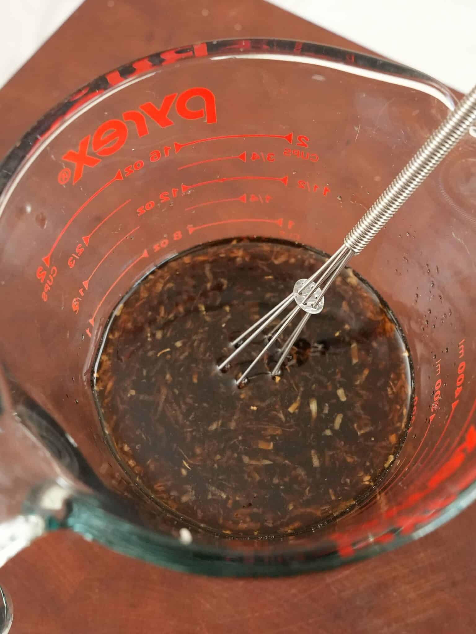 Homemade Teriyaki Sauce mixed in a measuring cup with a small whisk.