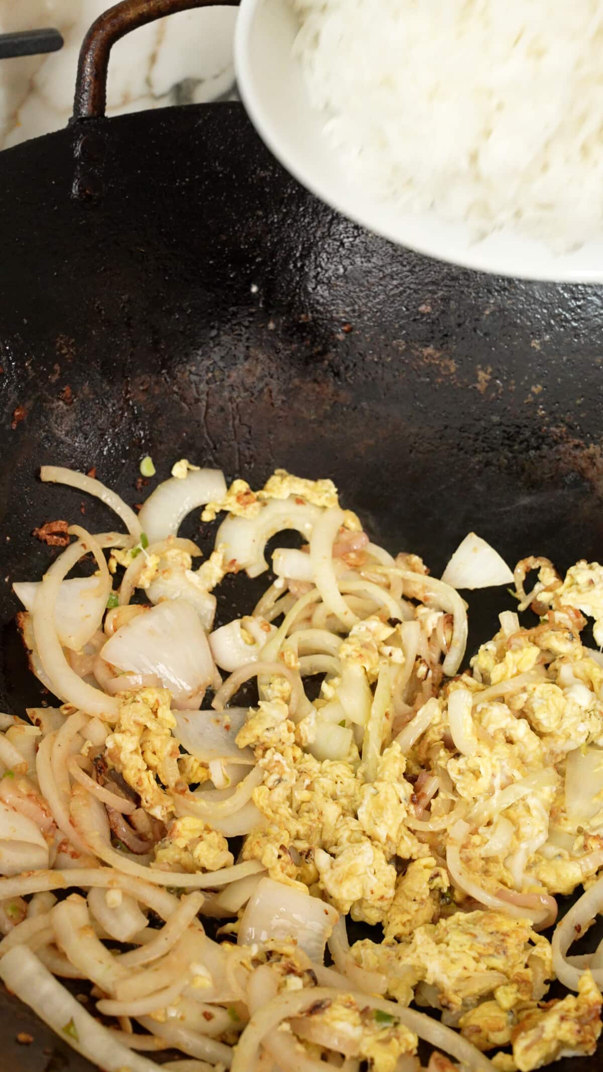 Eggs scrambled in a wok with onions, shallots, and thai chili and garlic paste.
