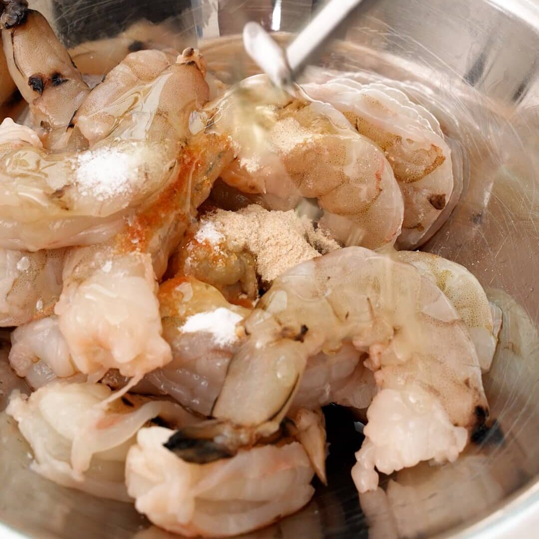Marinating shrimp in a metal bowl.