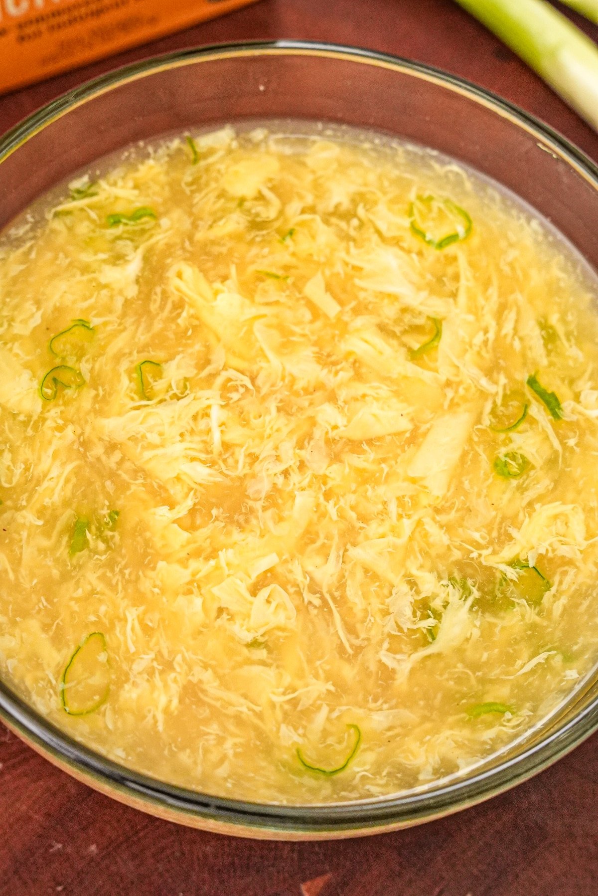 Egg drop soup in a glass bowl.