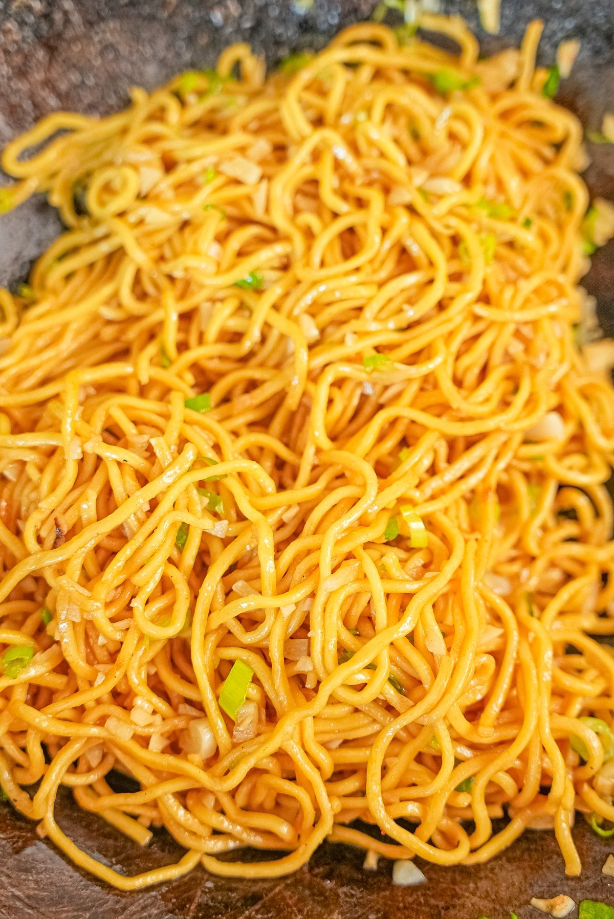 Garlic noodles tossed in a wok.