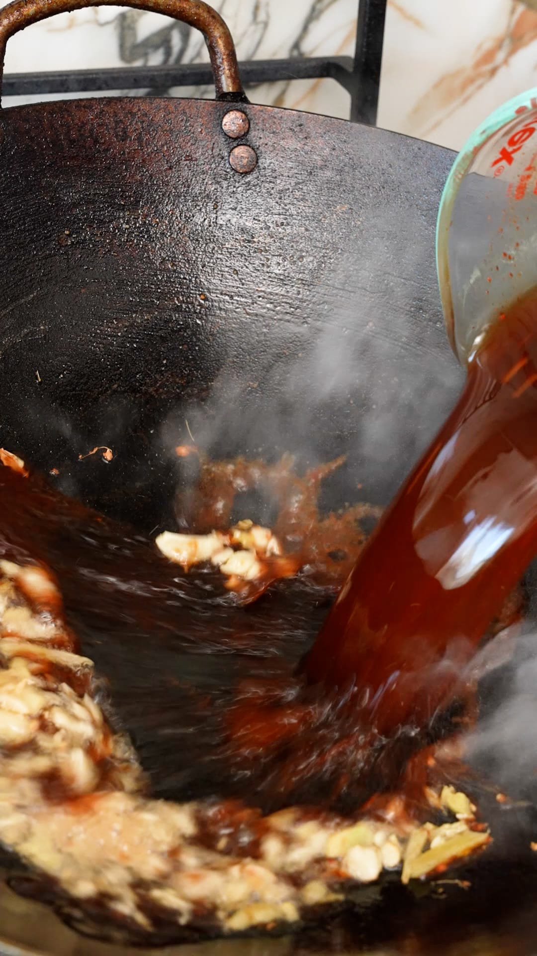 General Tso's Chicken sauce being added to the wok.