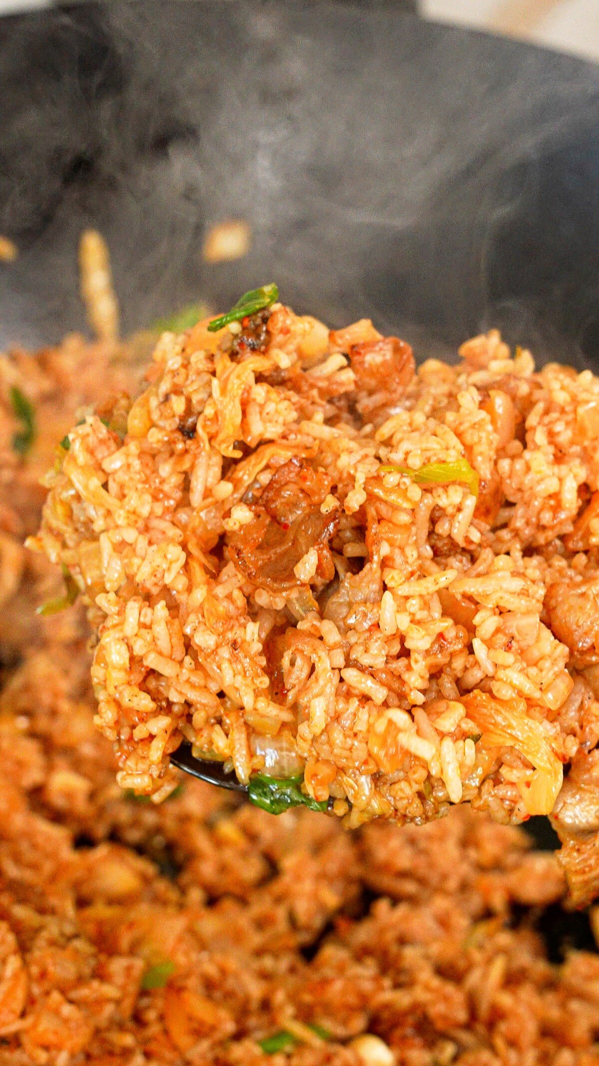 Kimchi Fried Rice on a spatula in a wok.