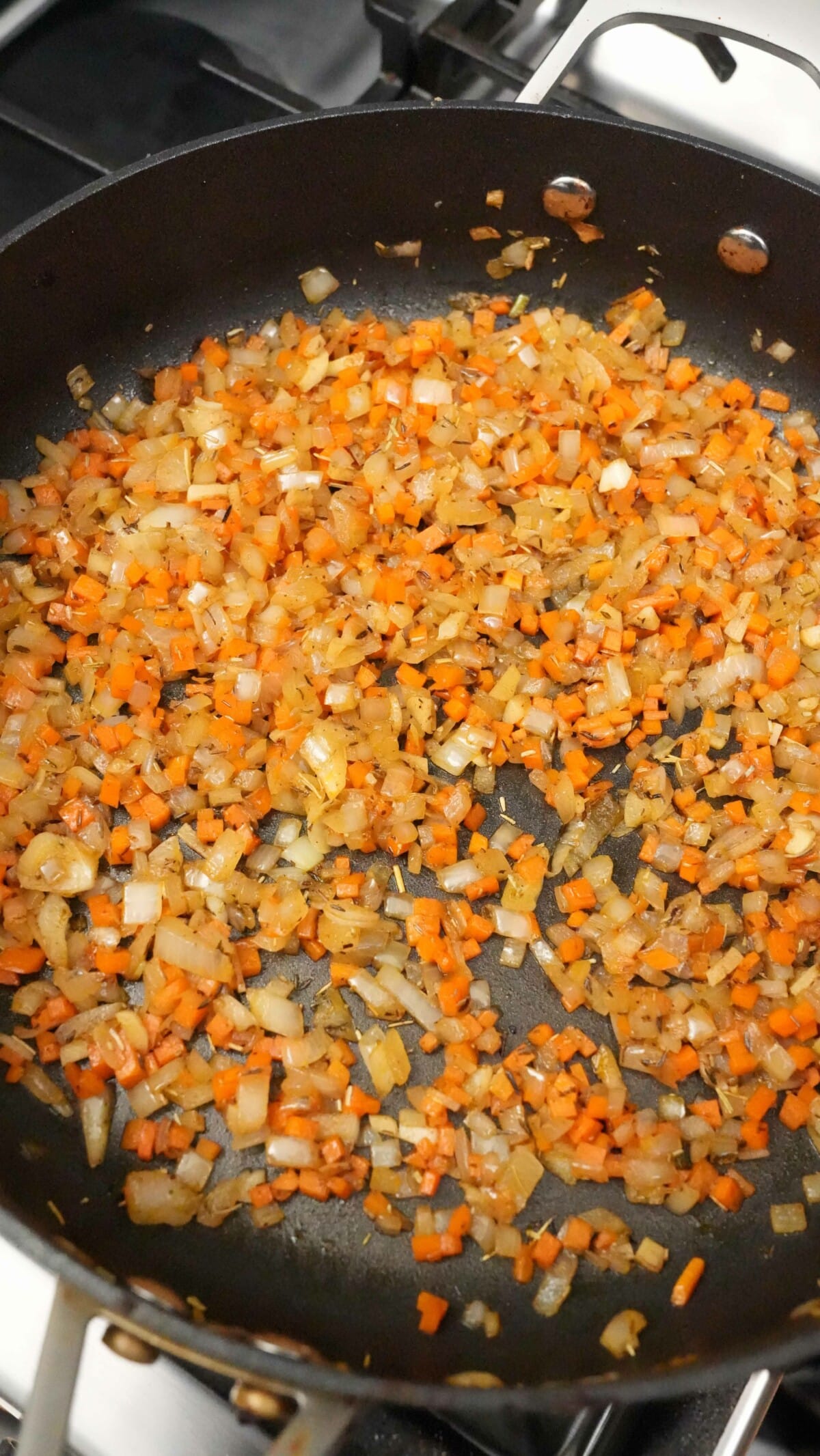 Onions, carrots, garlic and spices cooked in a pan.