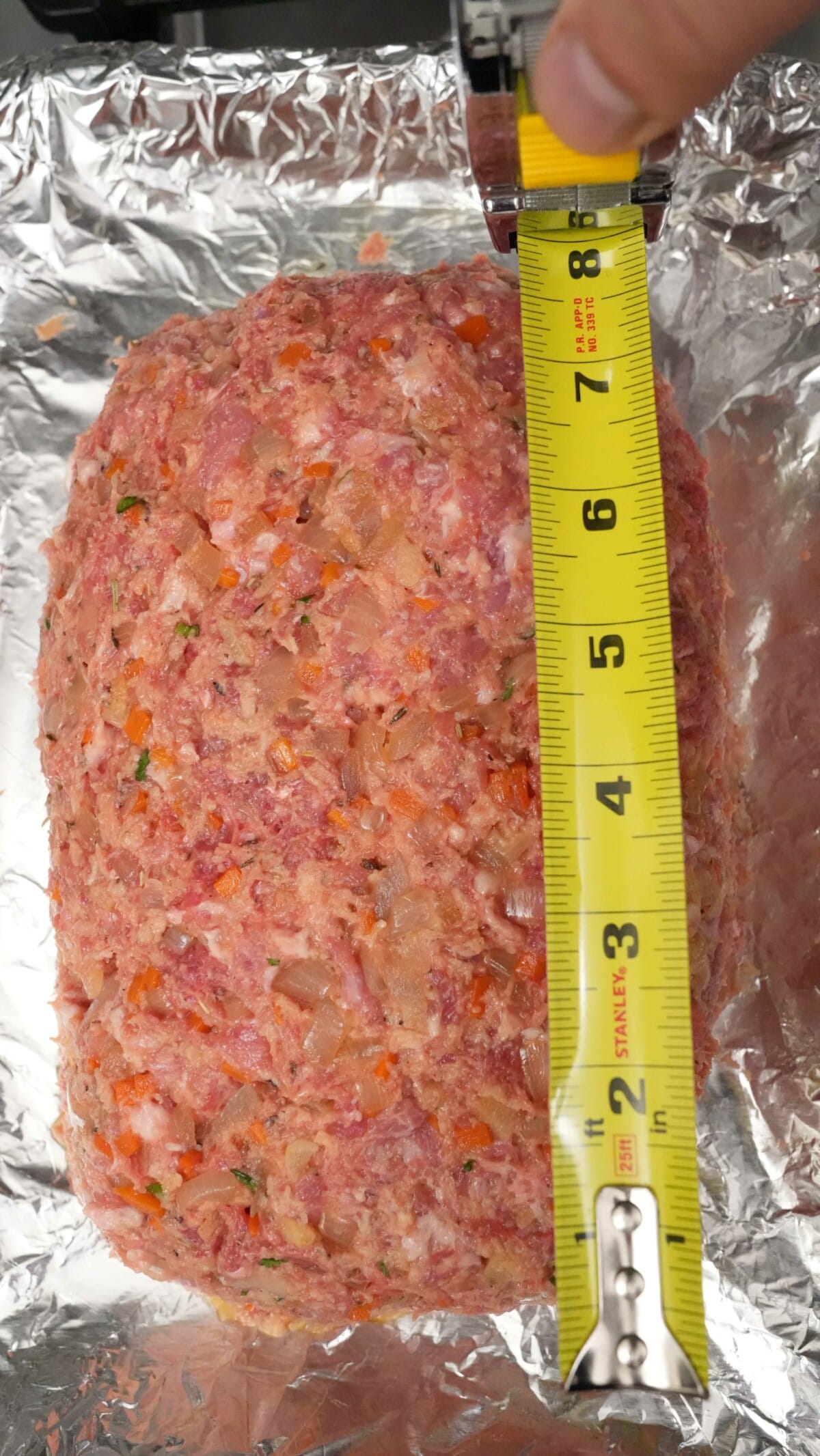 A measuring tape showing the length of the meatloaf.