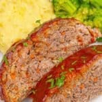 A plate of meatloaf slices with mashed potatoes and broccoli.