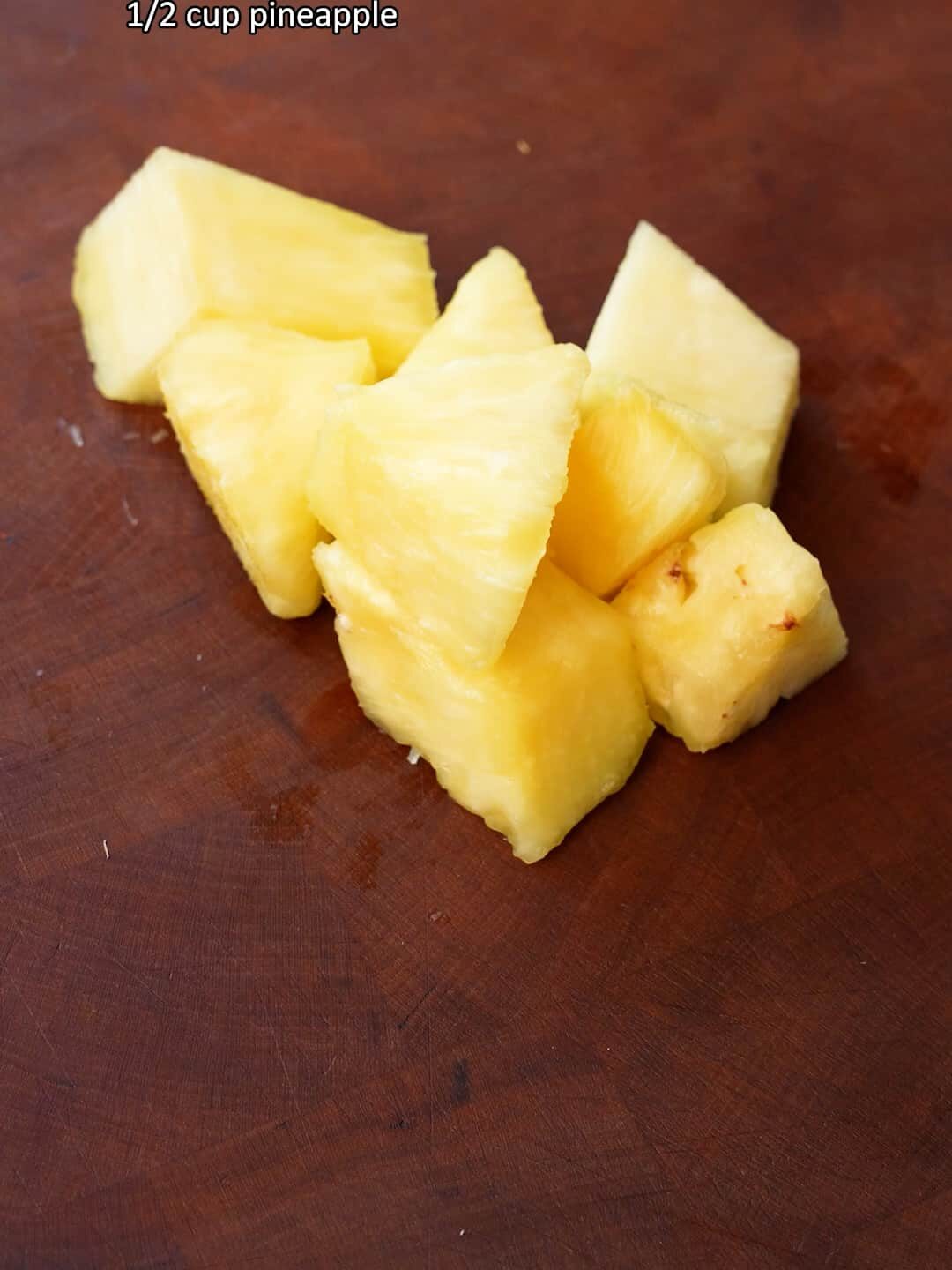 Cut pieces of pineapple on a cutting board.