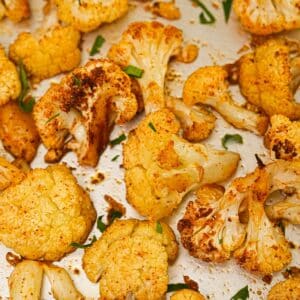 Crispy Roasted Cauliflower on a baking sheet with herbs.