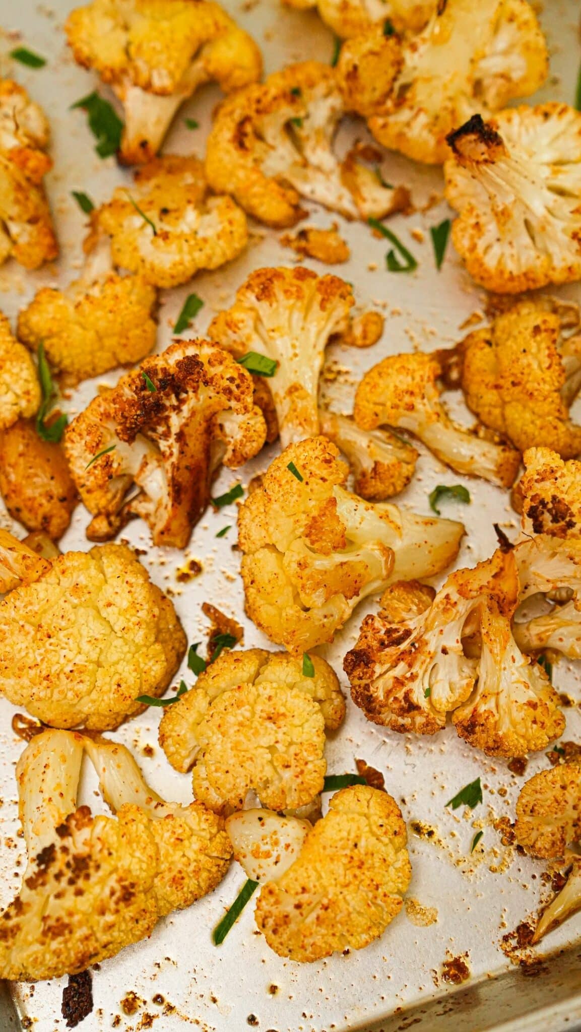 Crispy Roasted Cauliflower on a baking sheet with herbs.