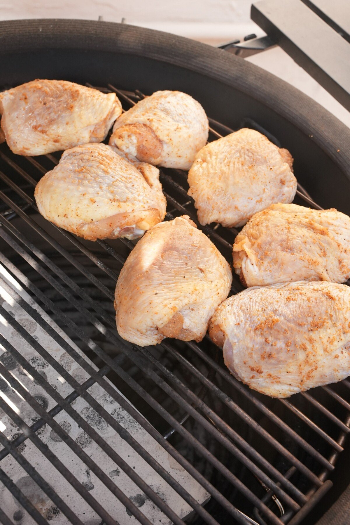Seasoned chicken thighs on the indirect side of the grill.