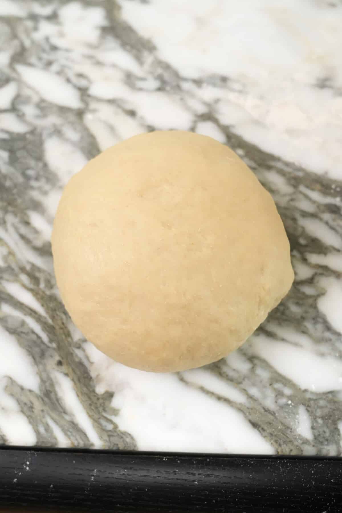 Milk bread dough kneaded and rolled into a ball.