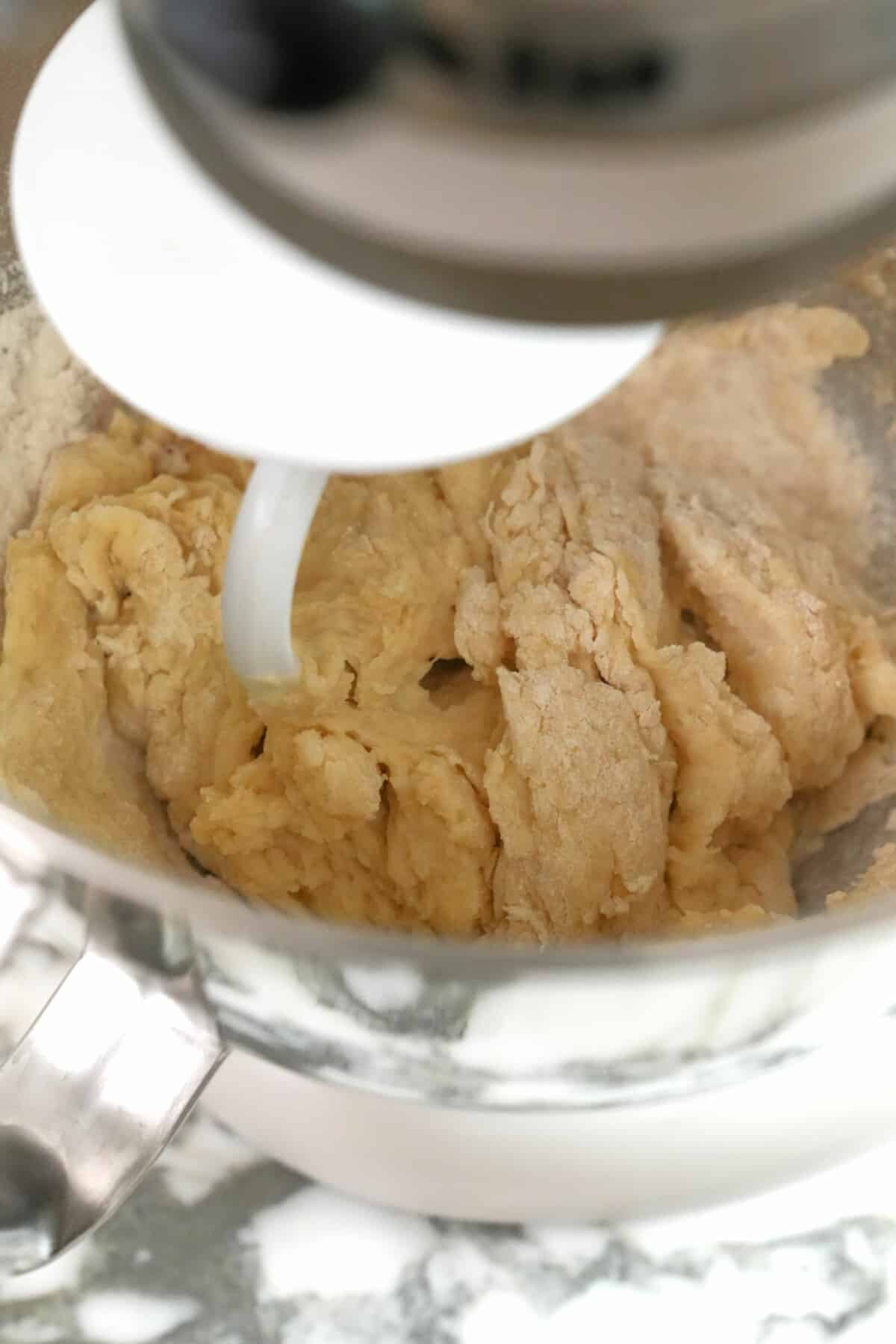 Milk bread dough mixing in a stand mixer.