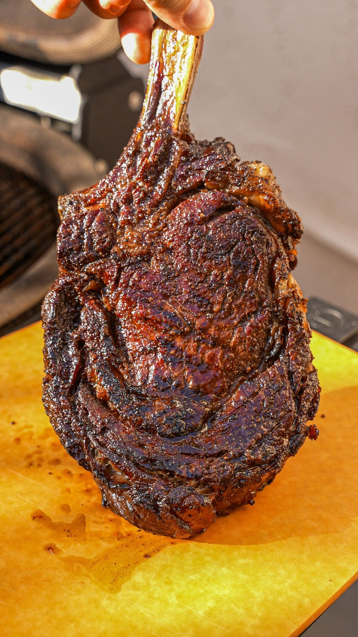 Cooked ribeye steak on a cutting board with an amazing crust.