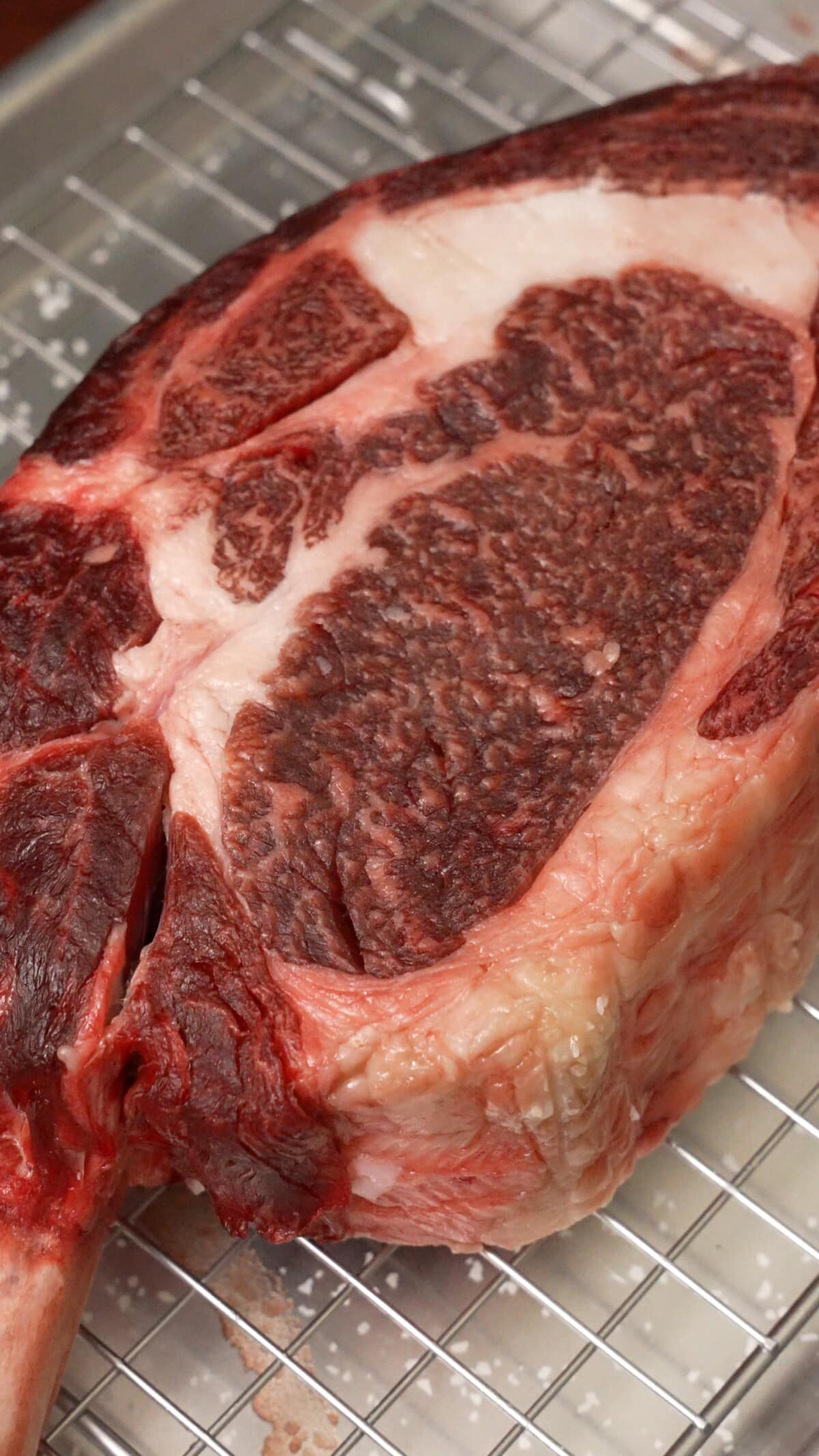 Raw steak on a wire rack after dry brining in the fridge for 2 days.