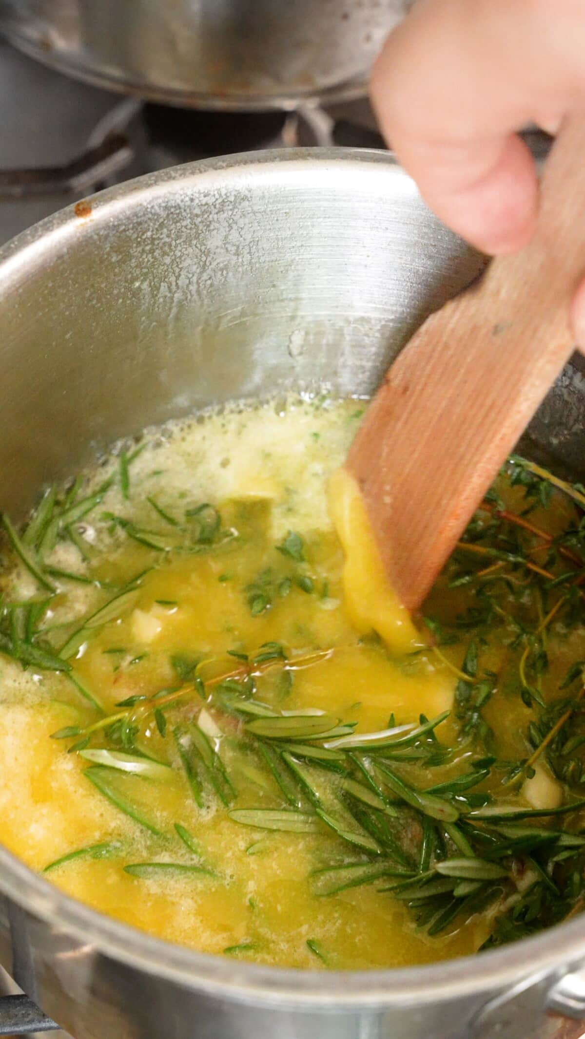 Cooking the garlic herb butter in a saucepan.