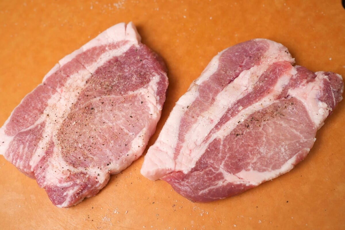 Pork loins tenderized by a knife and seasoned with salt and pepper.