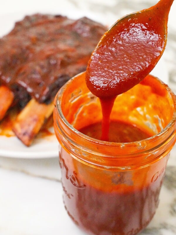 Homemade BBQ sauce in a jar with a spoon.