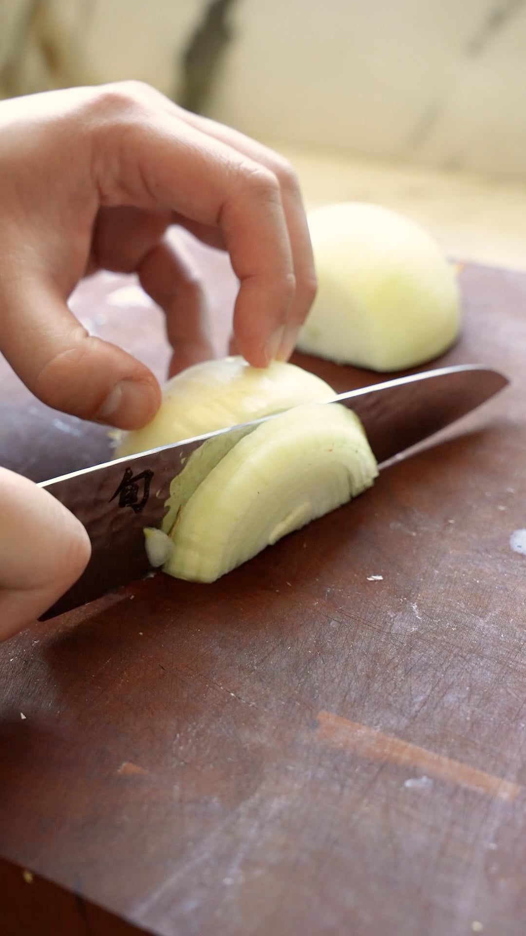 Onions being cut on a cutting board.