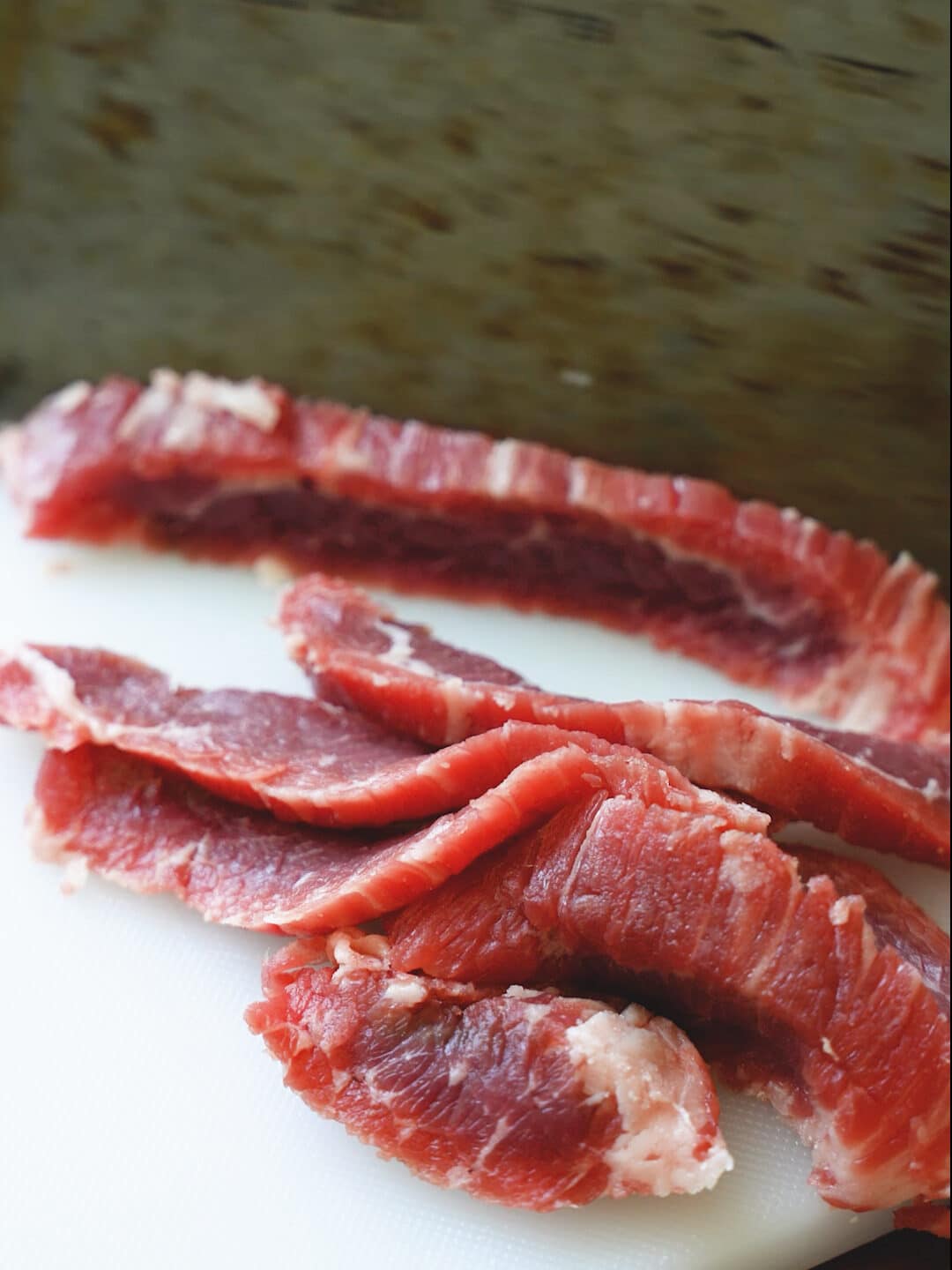 A cleaver slicing flank steak against the grain.