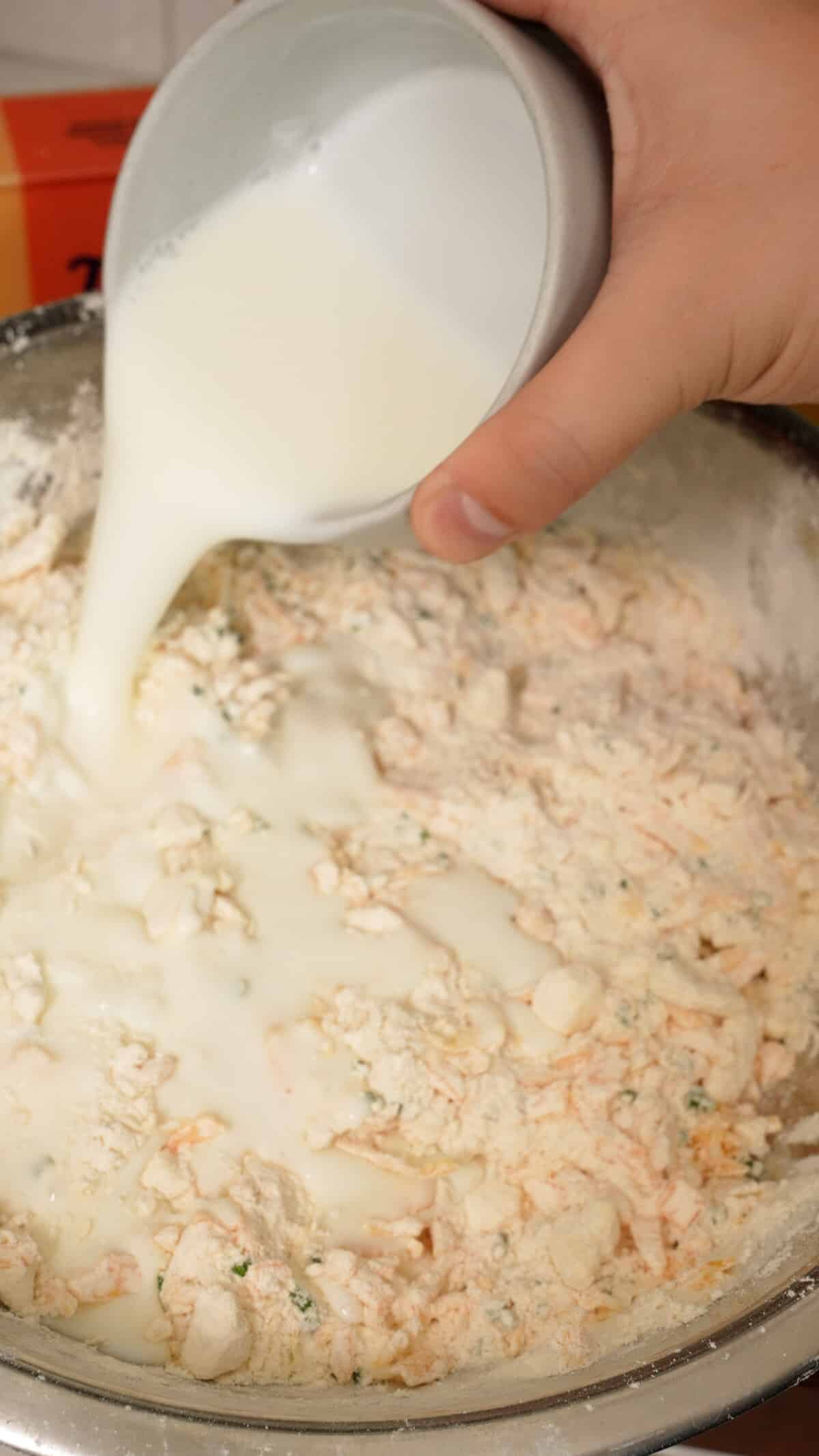 Cold buttermilk being added to the biscuit dough.