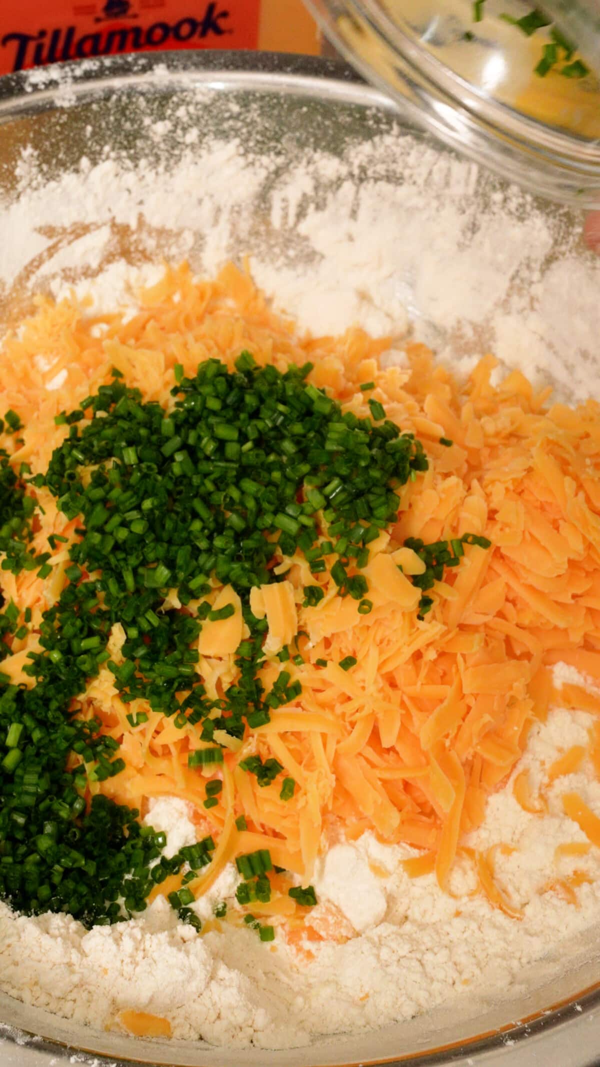 Cheddar and chives being added to the biscuit dough.