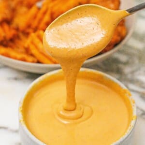 Chick-Fil-A sauce in a bowl in front of a bowl of waffle fries.