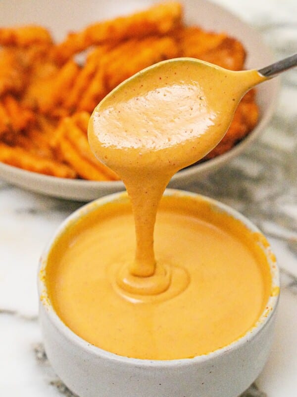 Chick-Fil-A sauce in a bowl in front of a bowl of waffle fries.