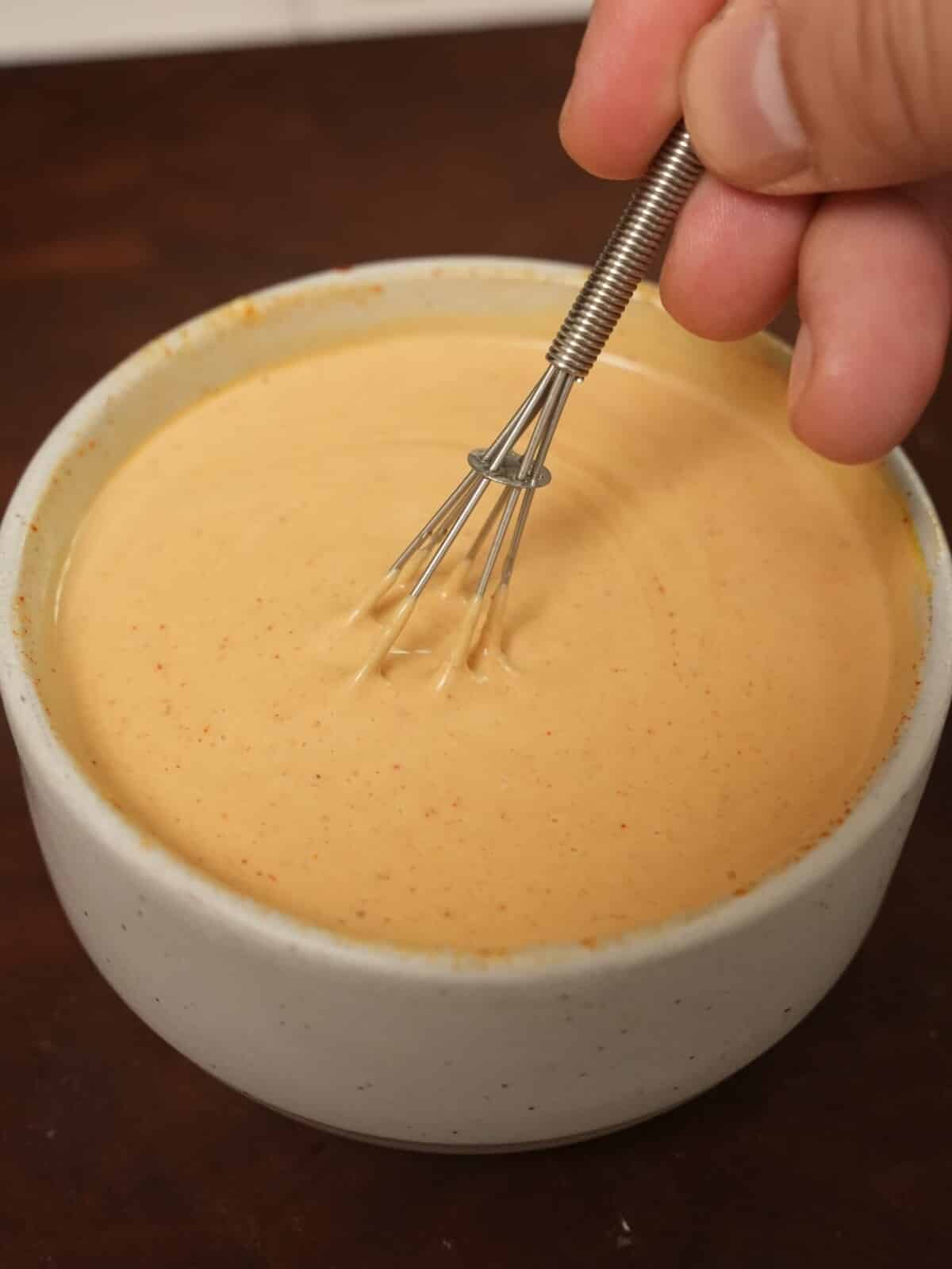 Mixing Chick-Fil-A sauce in a bowl with a small whisk.