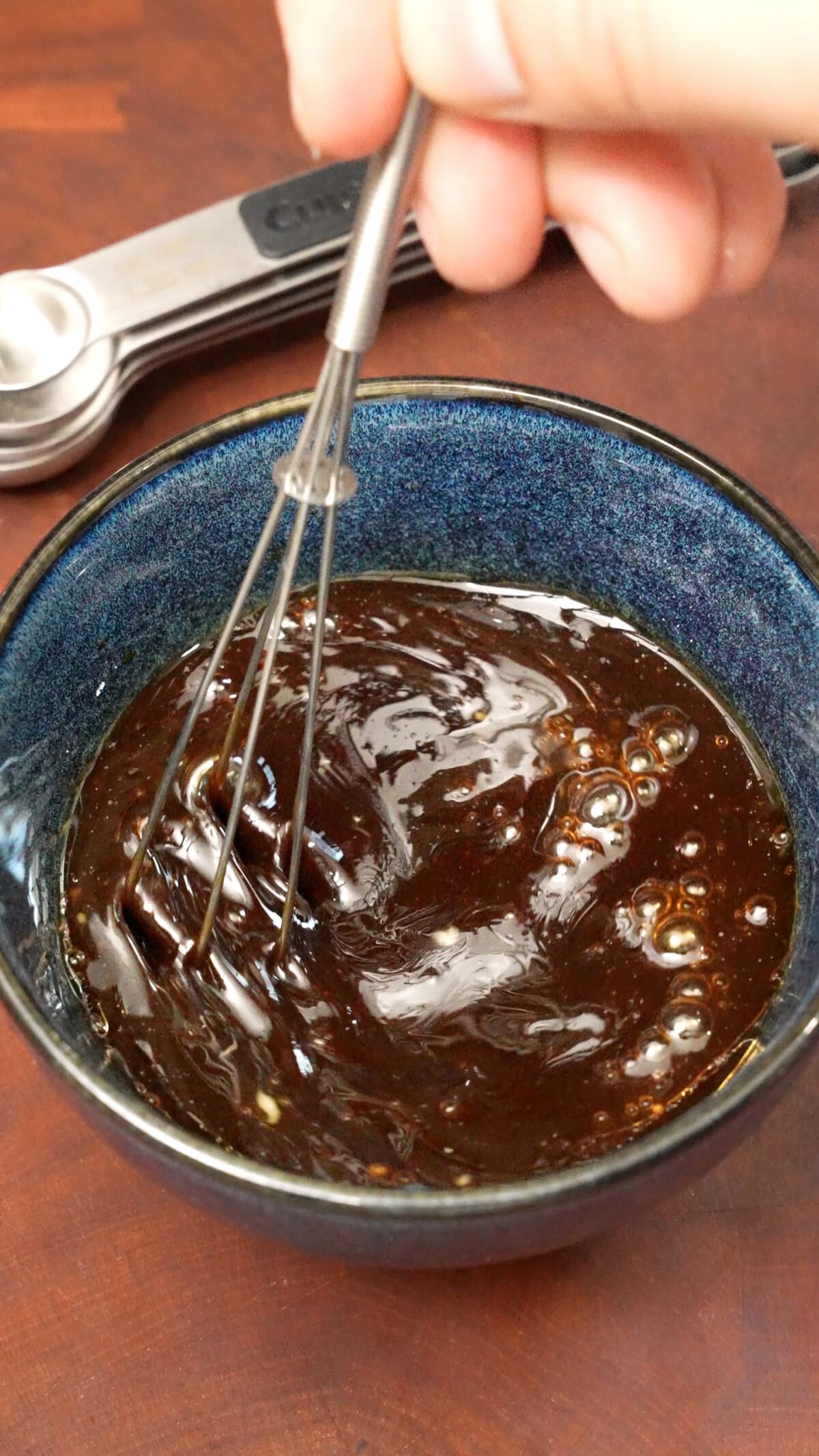 Chicken Lettuce wraps sauce being mixed in a small blue bowl.