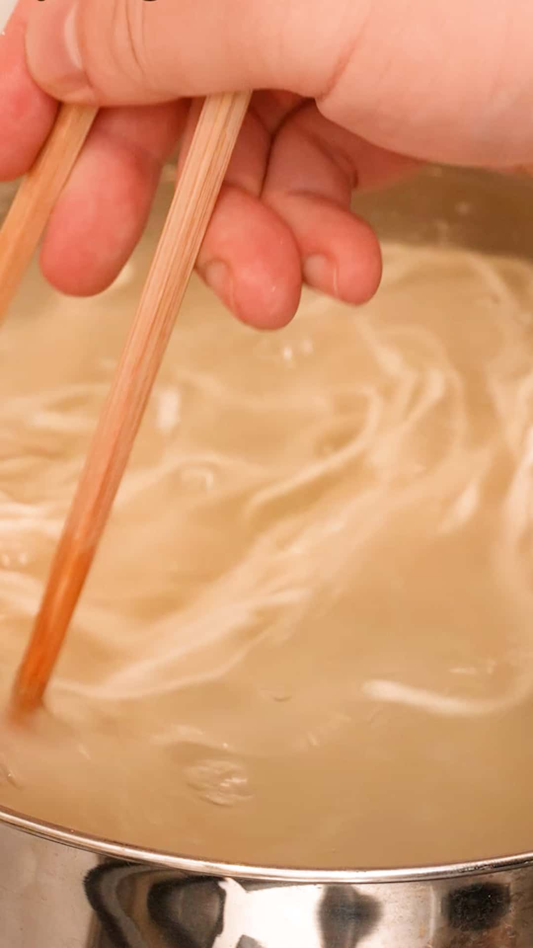 Cooking the fresh noodles in a pot of boiling water.