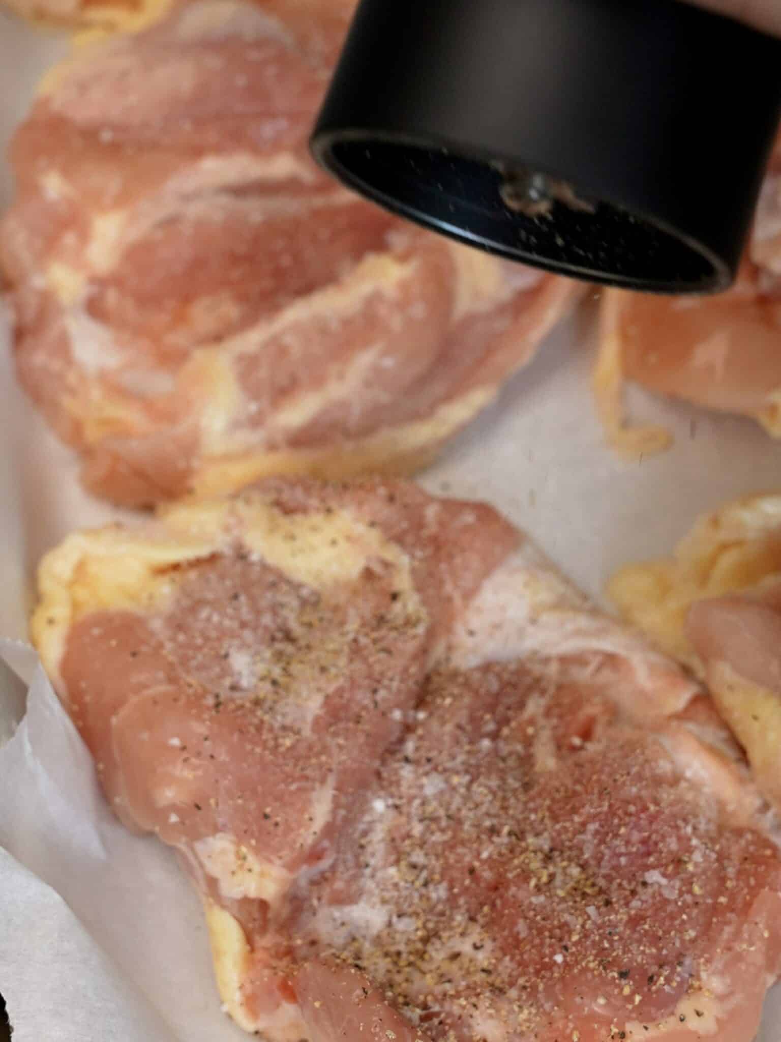 Seasoning chicken thigh with salt and pepper.