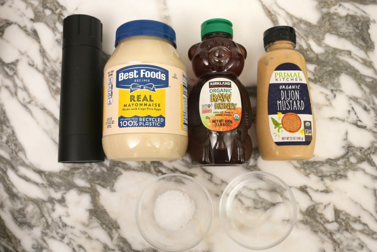 Raw ingredients for honey mustard sauce on a table.