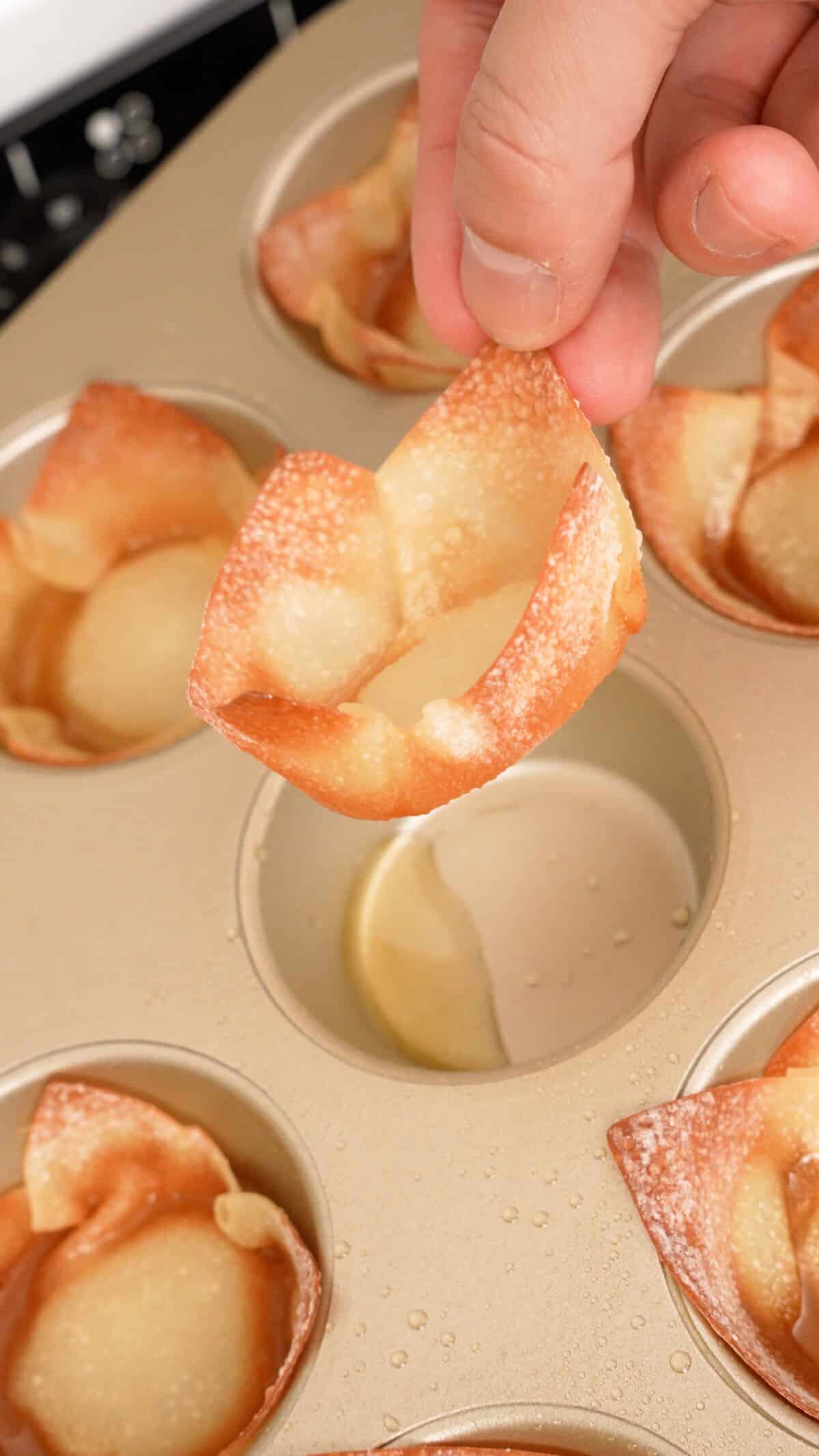 A crispy wonton cup pulled from a muffin tin.