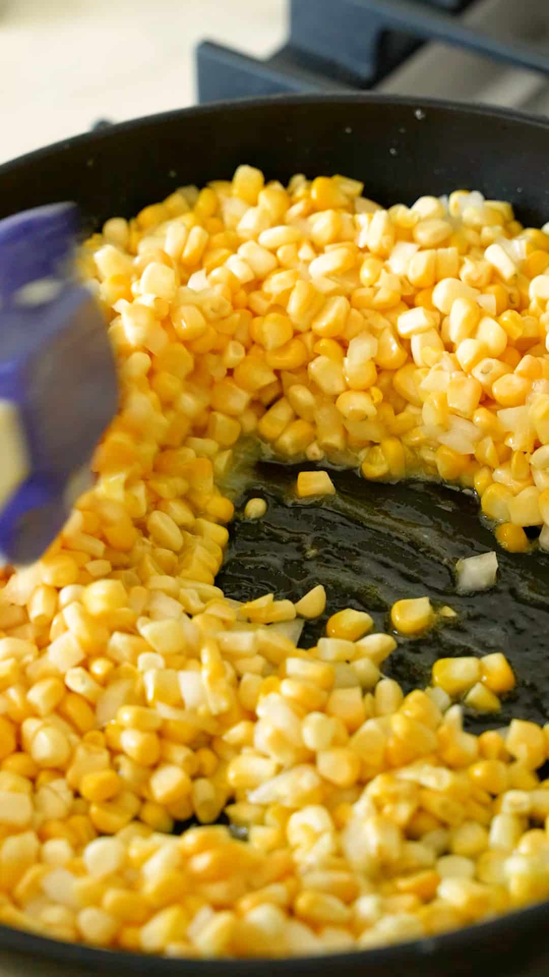 Cooking the corn and onion in butter in a pan.