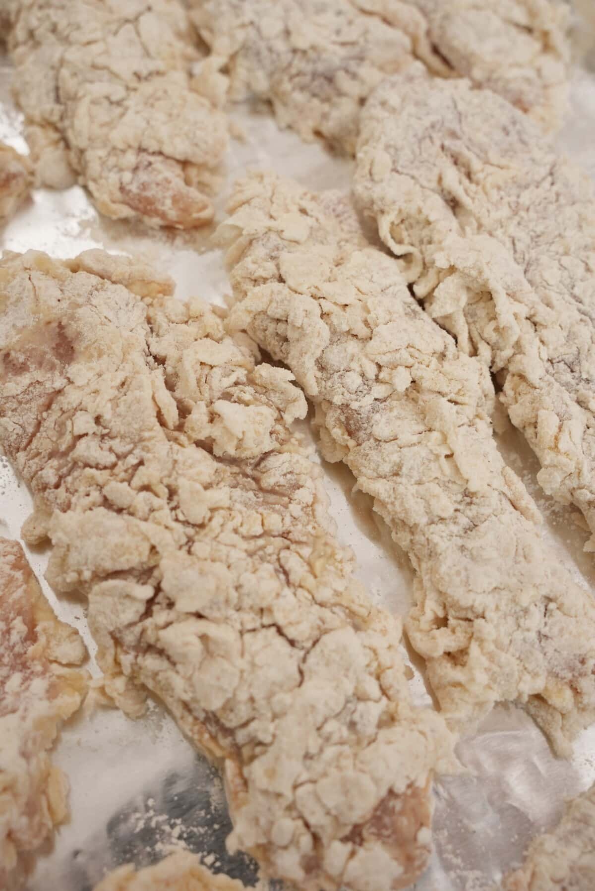 Korean fried chicken battered in fry mix resting on a tray.