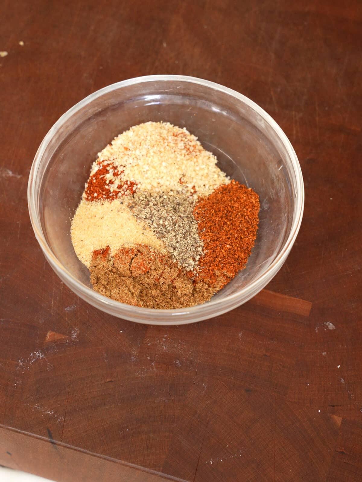 Spice mixture for the sausage in a glass bowl.