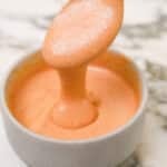A photo of copycat Raising Cane's sauce in a bowl with a spoon full of sauce.