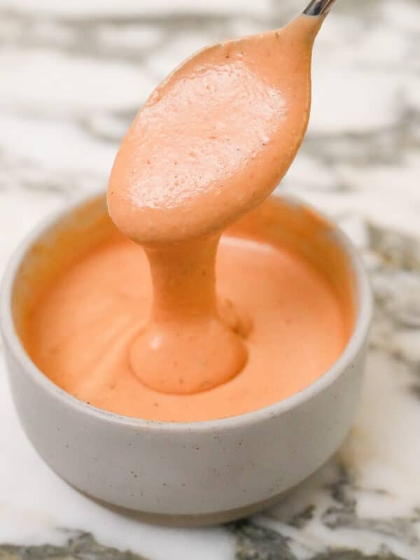 A photo of copycat Raising Cane's sauce in a bowl with a spoon full of sauce.