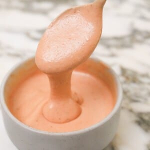 Raising Cane's sauce in a bowl with a spoon.