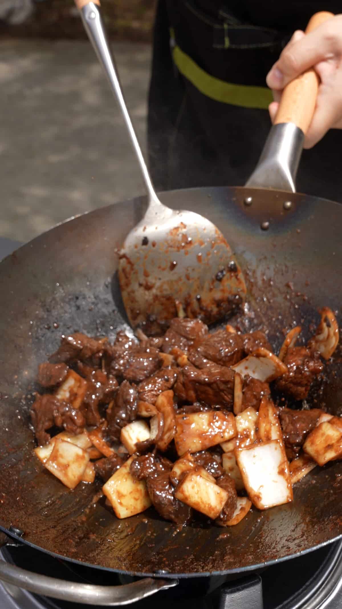 Beef and onions cooking in a wok.