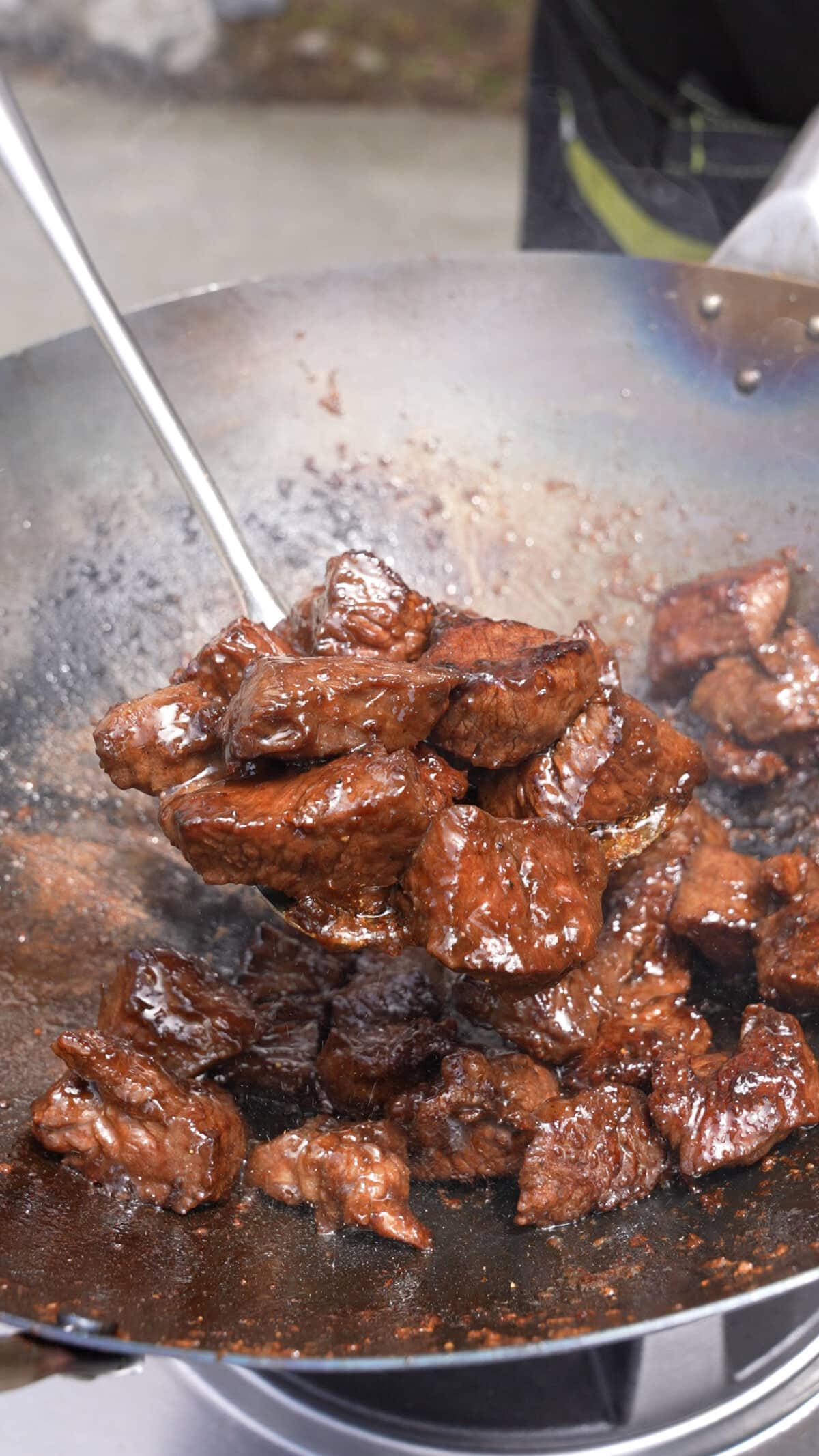 A spatula full of shaking beef showing the sear on the beef.