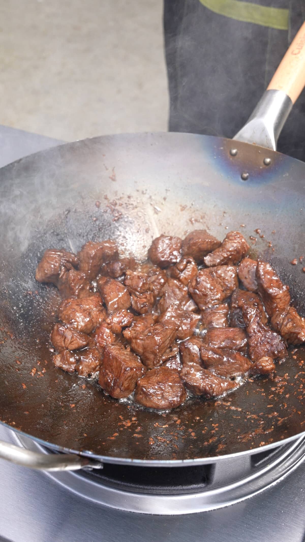 Shaking beef searing in a wok.