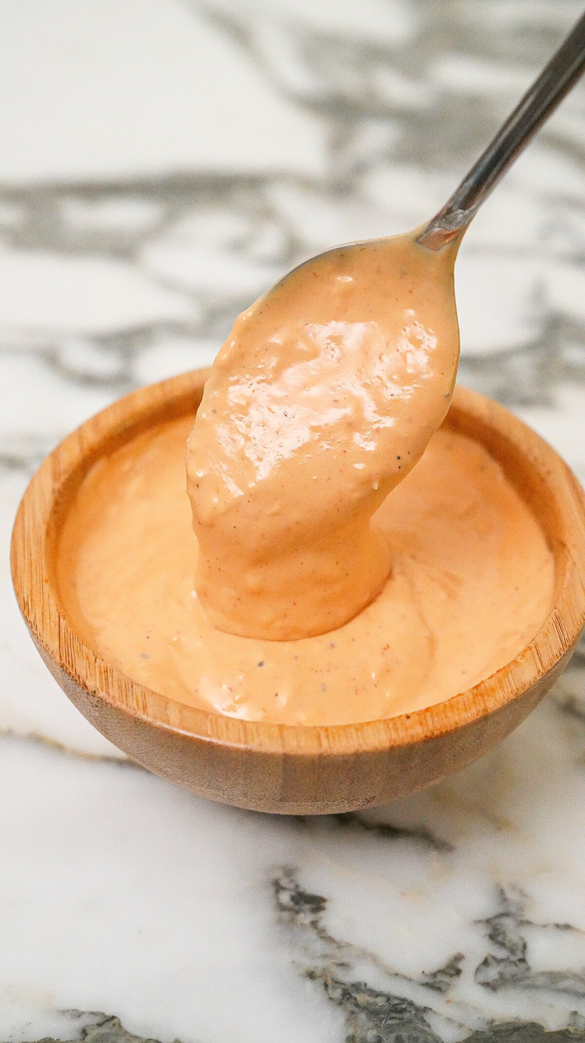 Homemade spicy mayo in a bowl with a spoon.