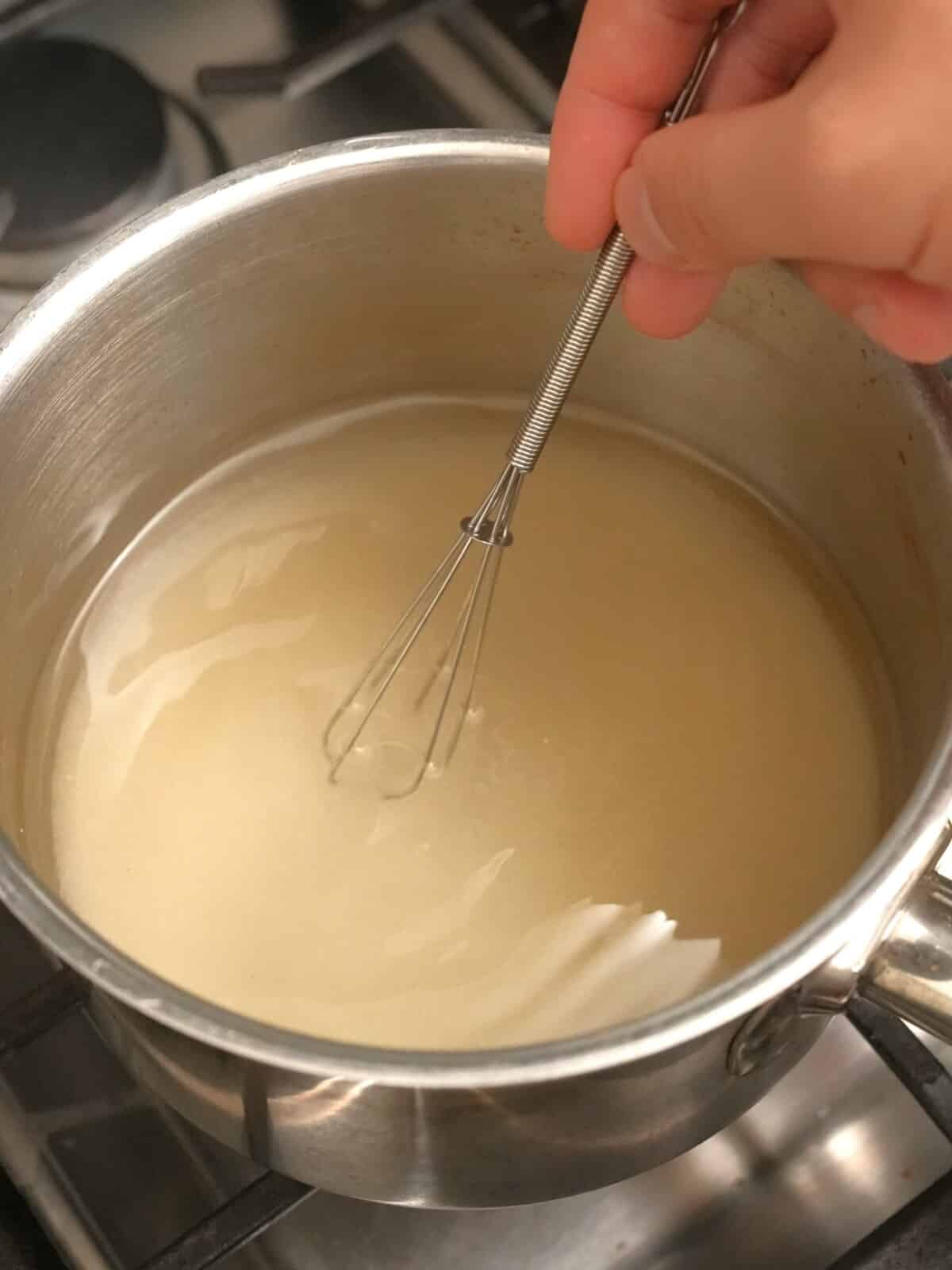 Mixing sugar and water in a small saucepan until dissolved.