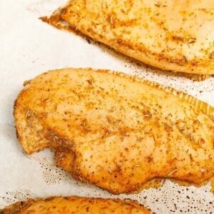 Baked chicken breasts cooked on a tray.