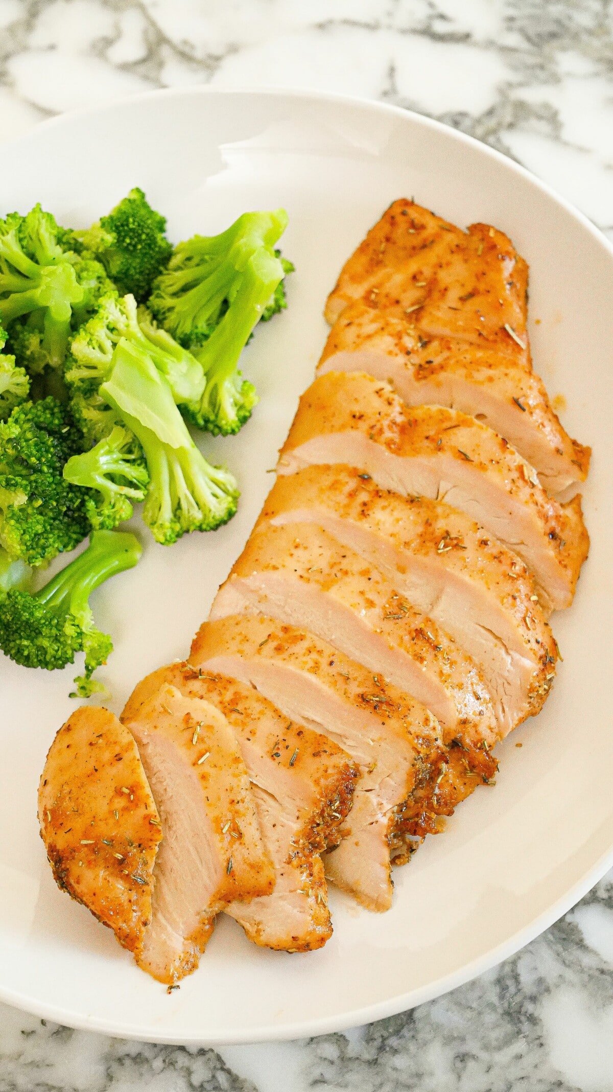 Baked Chicken Breast on a plate with broccoli.