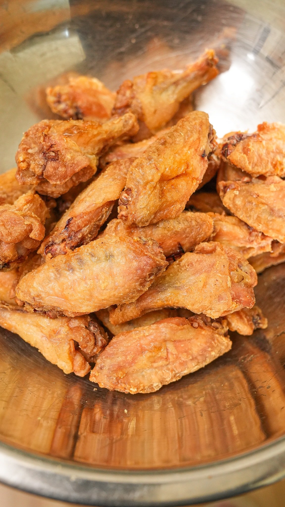 Crispy baked chicken wings in a metal bowl.