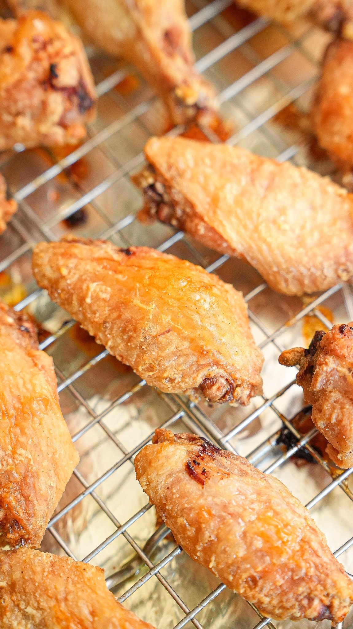 Baked chicken wings on a wire rack after baking.